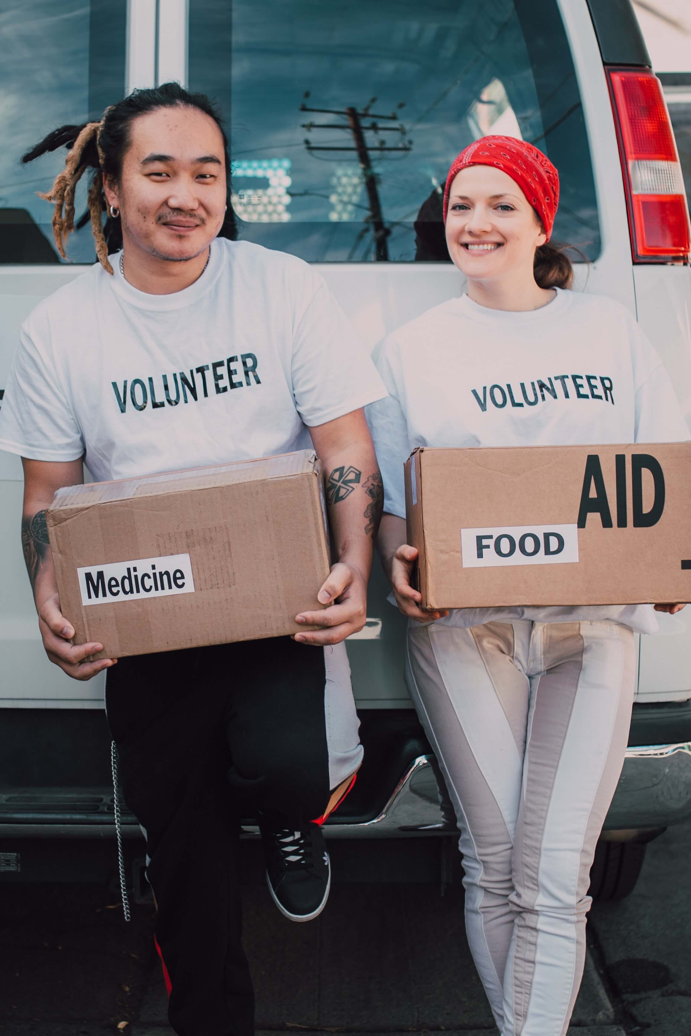Two people holding boxes bringing aid